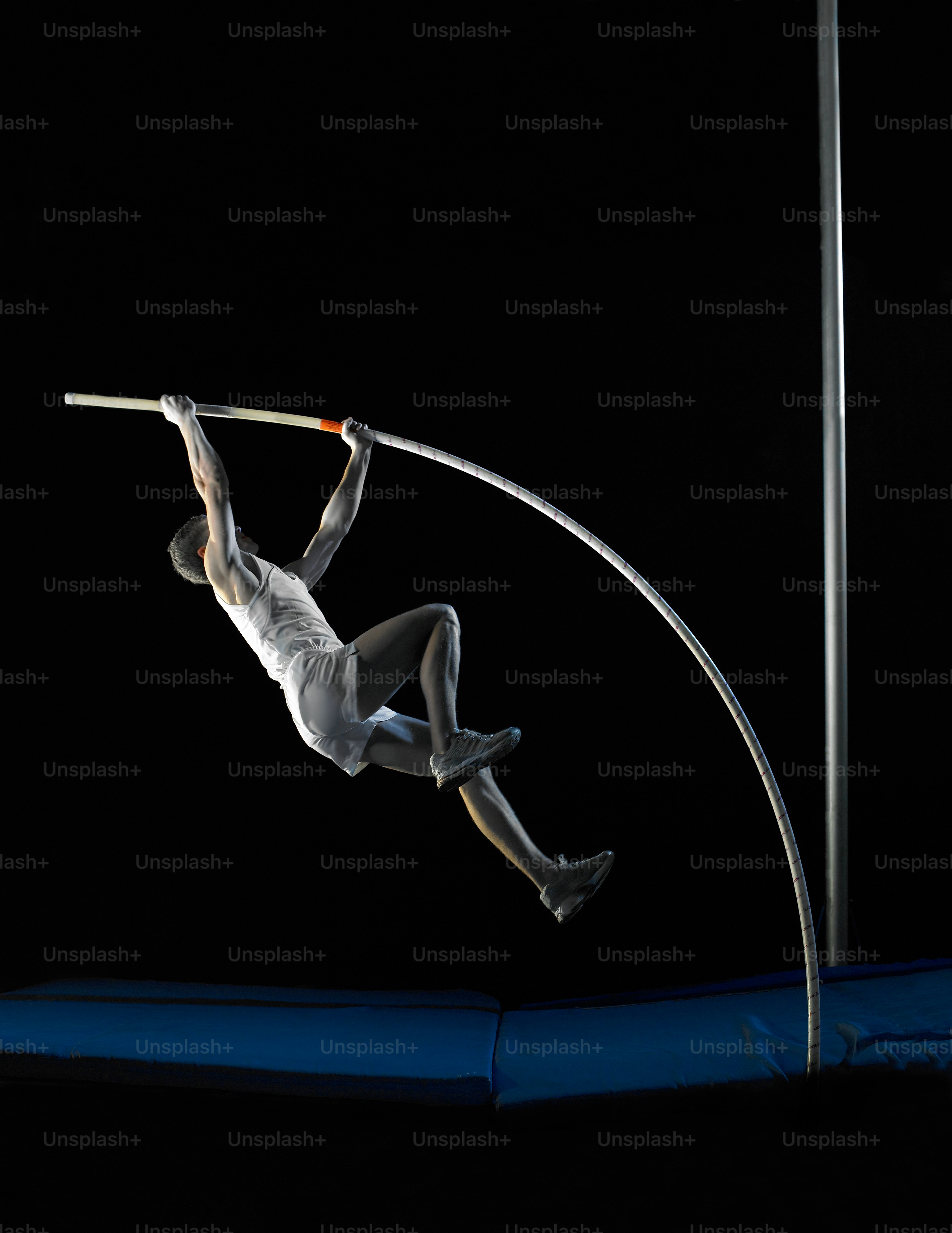 a man on a pole doing tricks on a trampoline