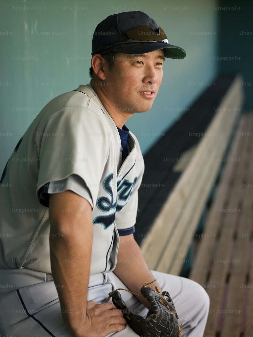 Ein Mann in Baseball-Uniform, der auf einer Bank sitzt