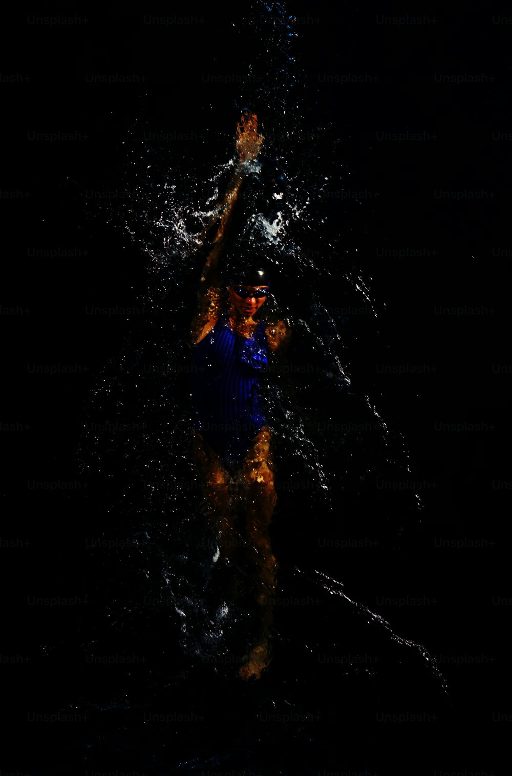 a woman in a blue swimsuit is swimming in the water
