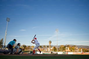 um jogador de beisebol segurando um bastão em cima de um campo