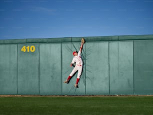 Un joueur de baseball appuyé contre un mur, le bras en l’air
