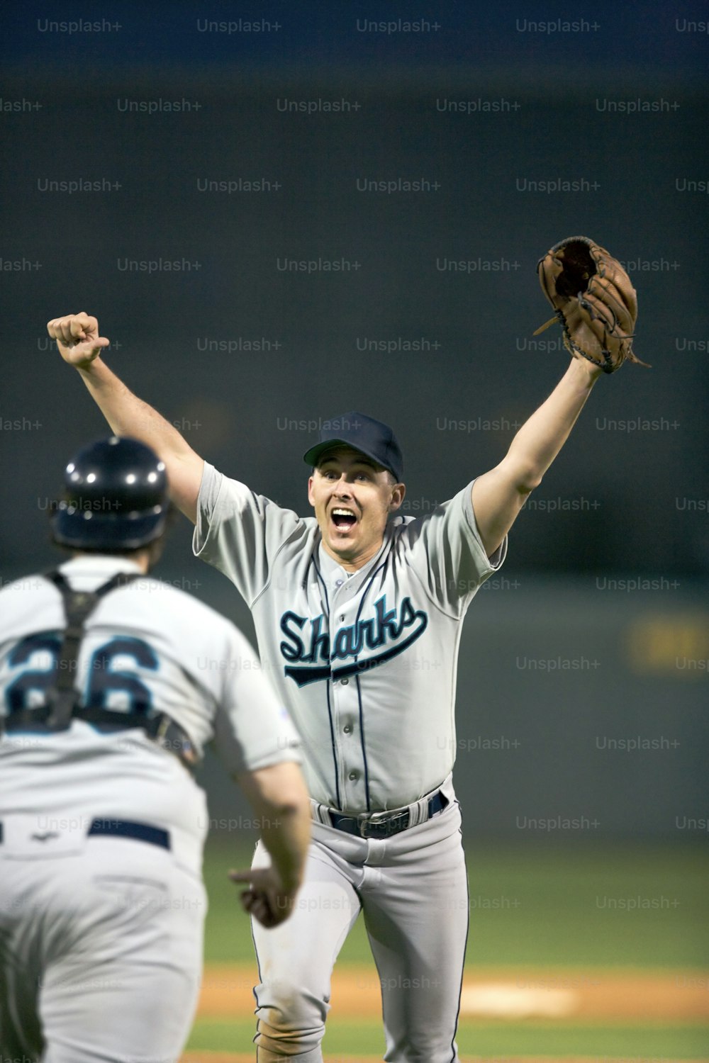 a baseball player holding a glove up in the air
