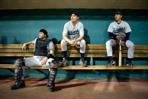 three baseball players are sitting on a bench