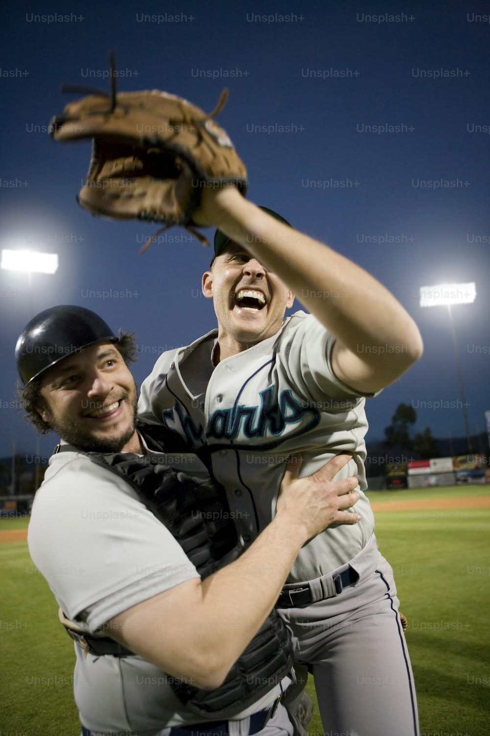 a couple of men standing on top of a baseball field