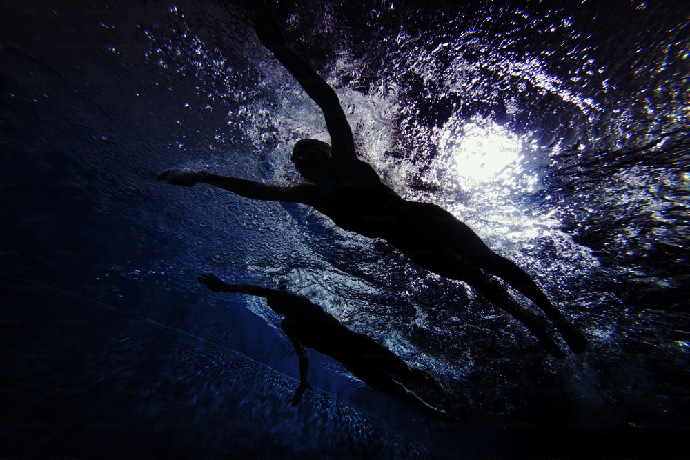 a woman swimming under water in a pool