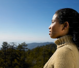 una donna in piedi in cima a una collina verde lussureggiante