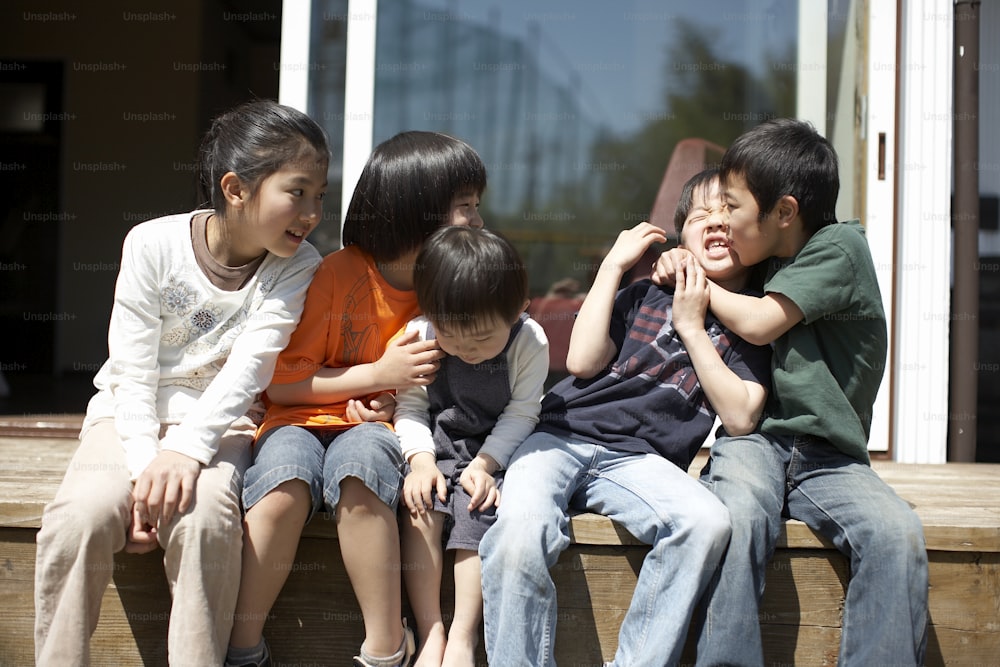 a group of children sitting on a wooden bench