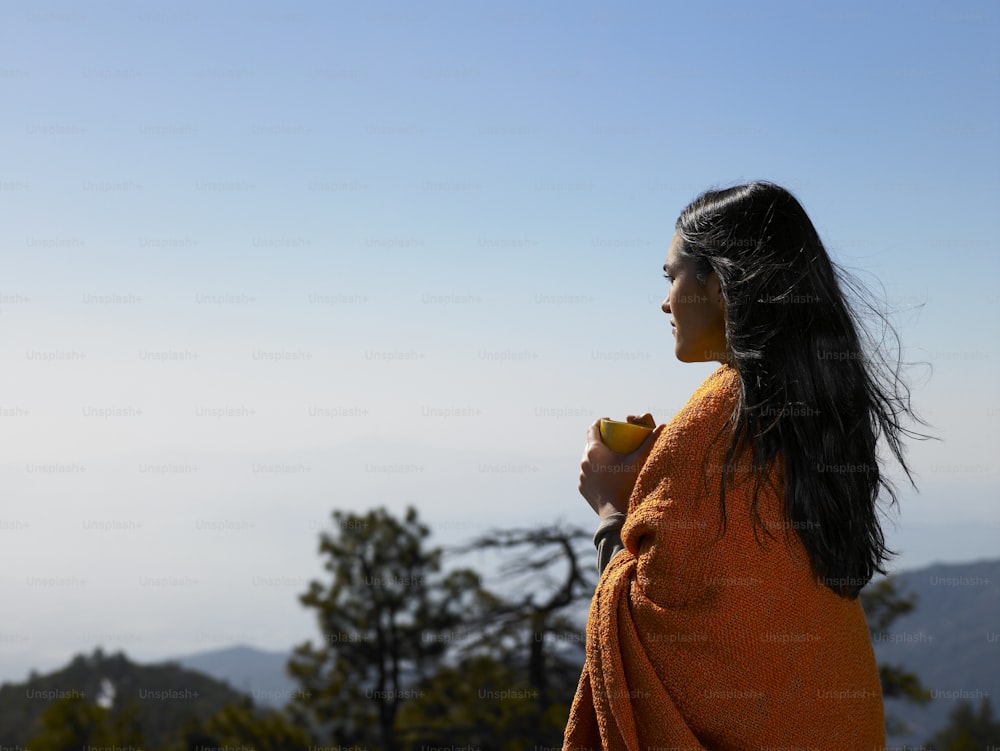 a woman in an orange robe eating a piece of fruit