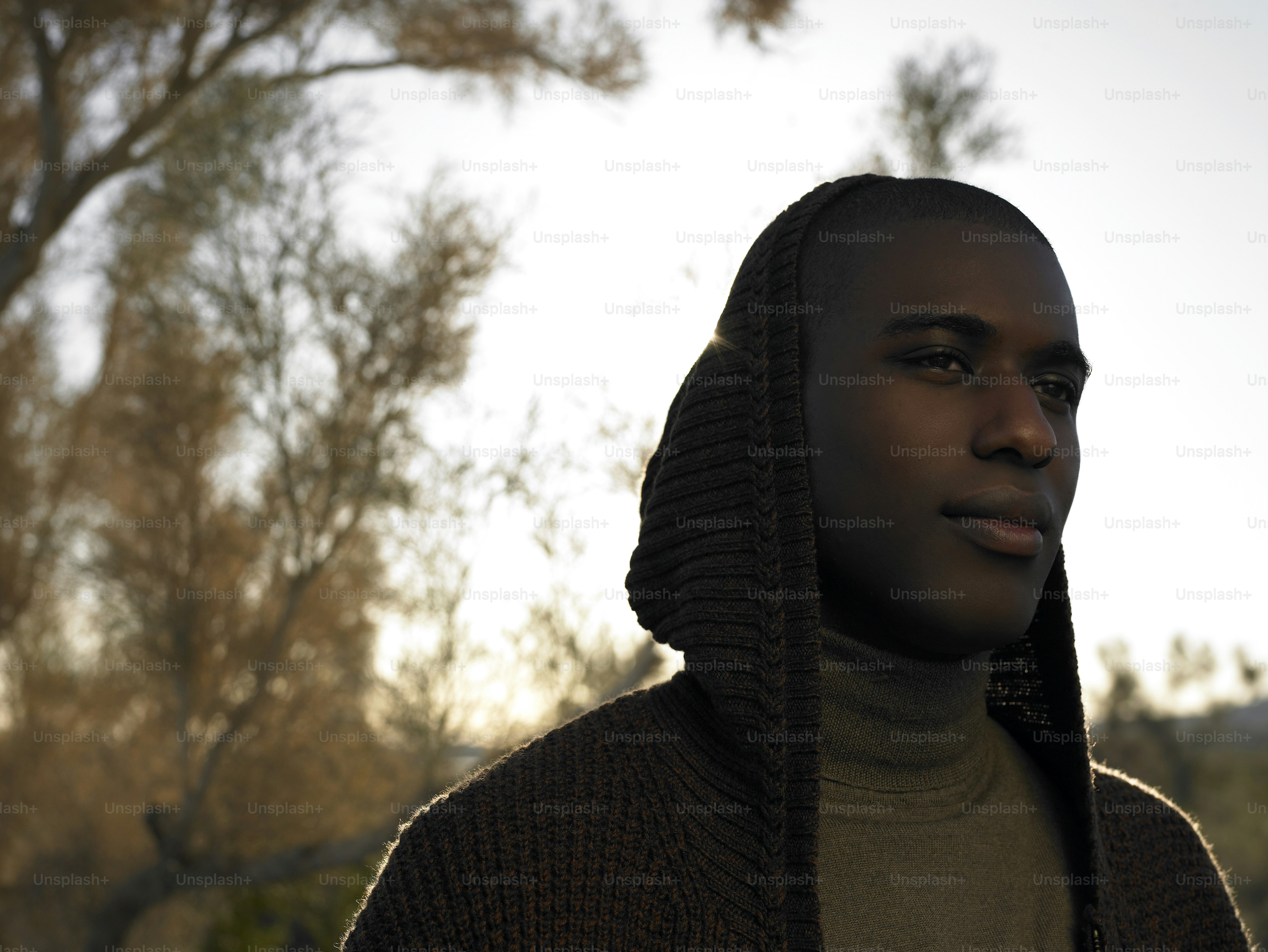 a man wearing a brown sweater and a hoodie