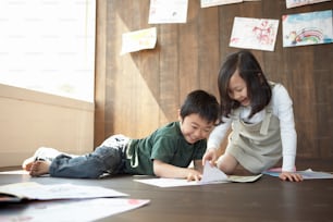a couple of kids laying on top of a wooden floor