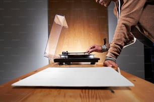 a person standing over a record player on a table