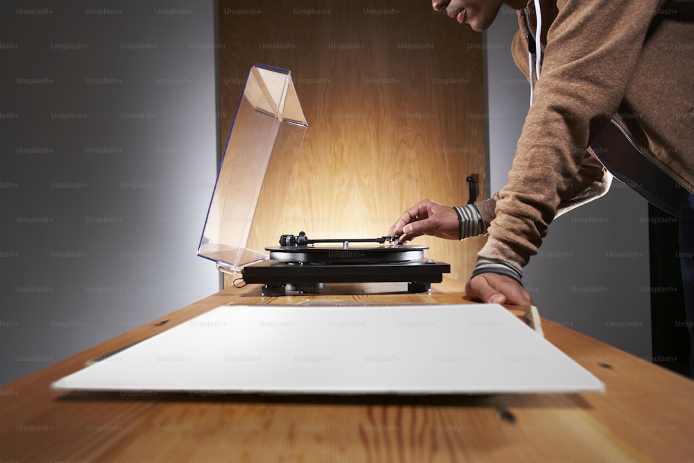 a person standing over a record player on a table