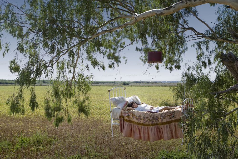 una persona che giace in un letto sotto un albero