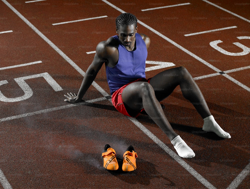 a woman sitting on a track with her feet on the ground