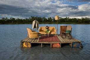 a woman sitting on a couch on a dock