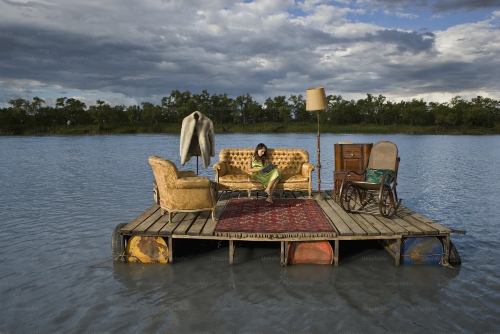 a woman sitting on a couch on a dock