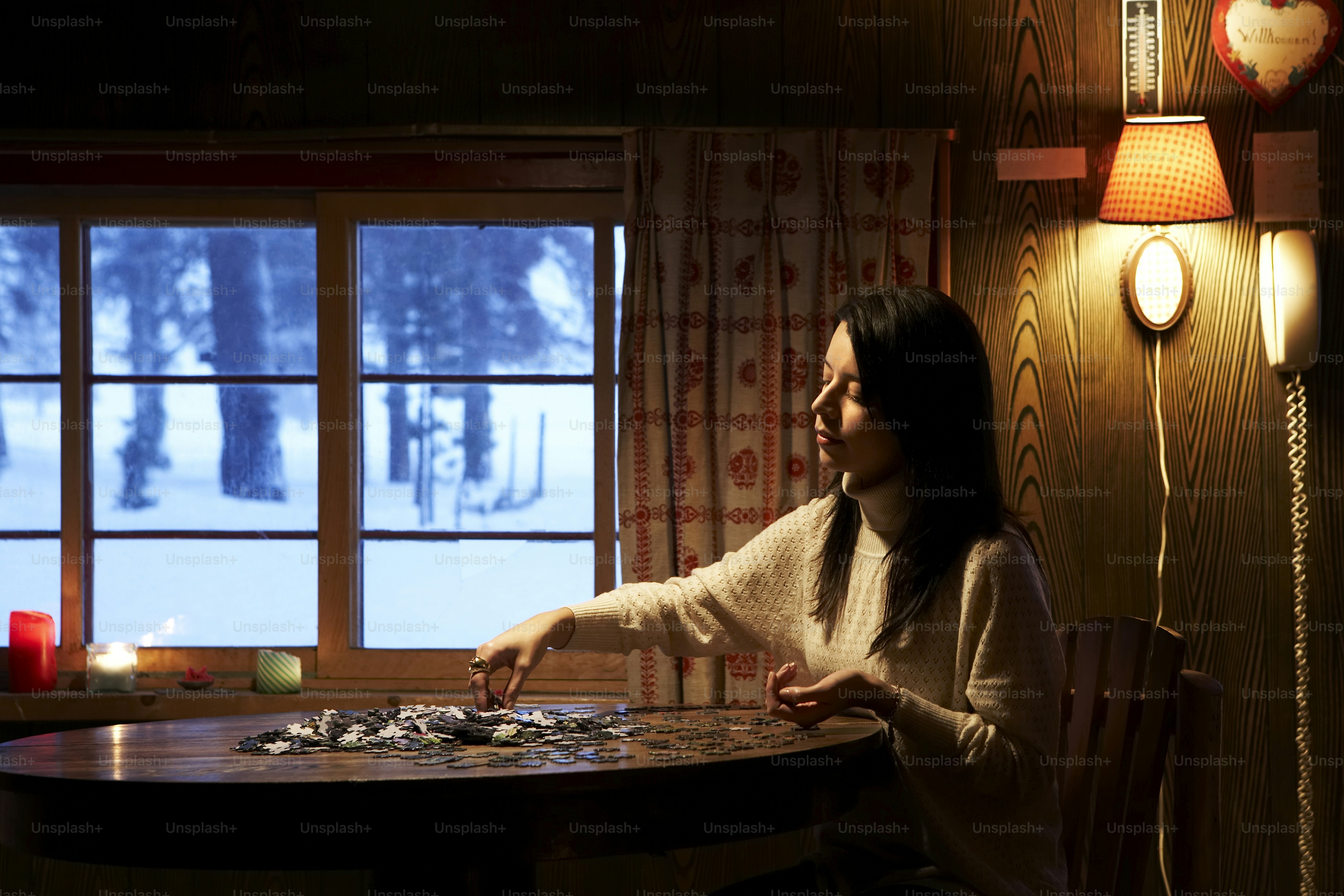 a woman sitting at a table in front of a window