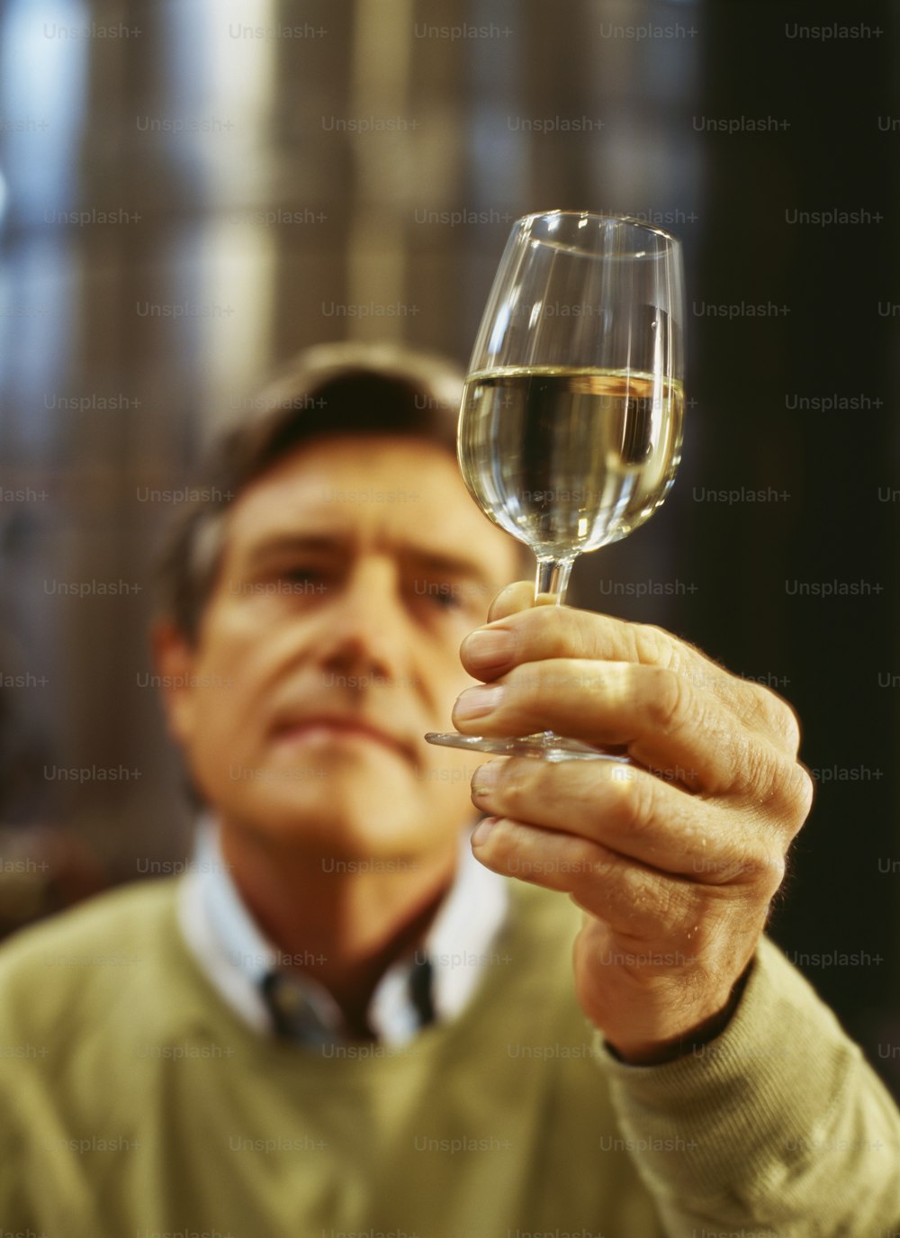 um homem segurando uma taça de vinho na mão