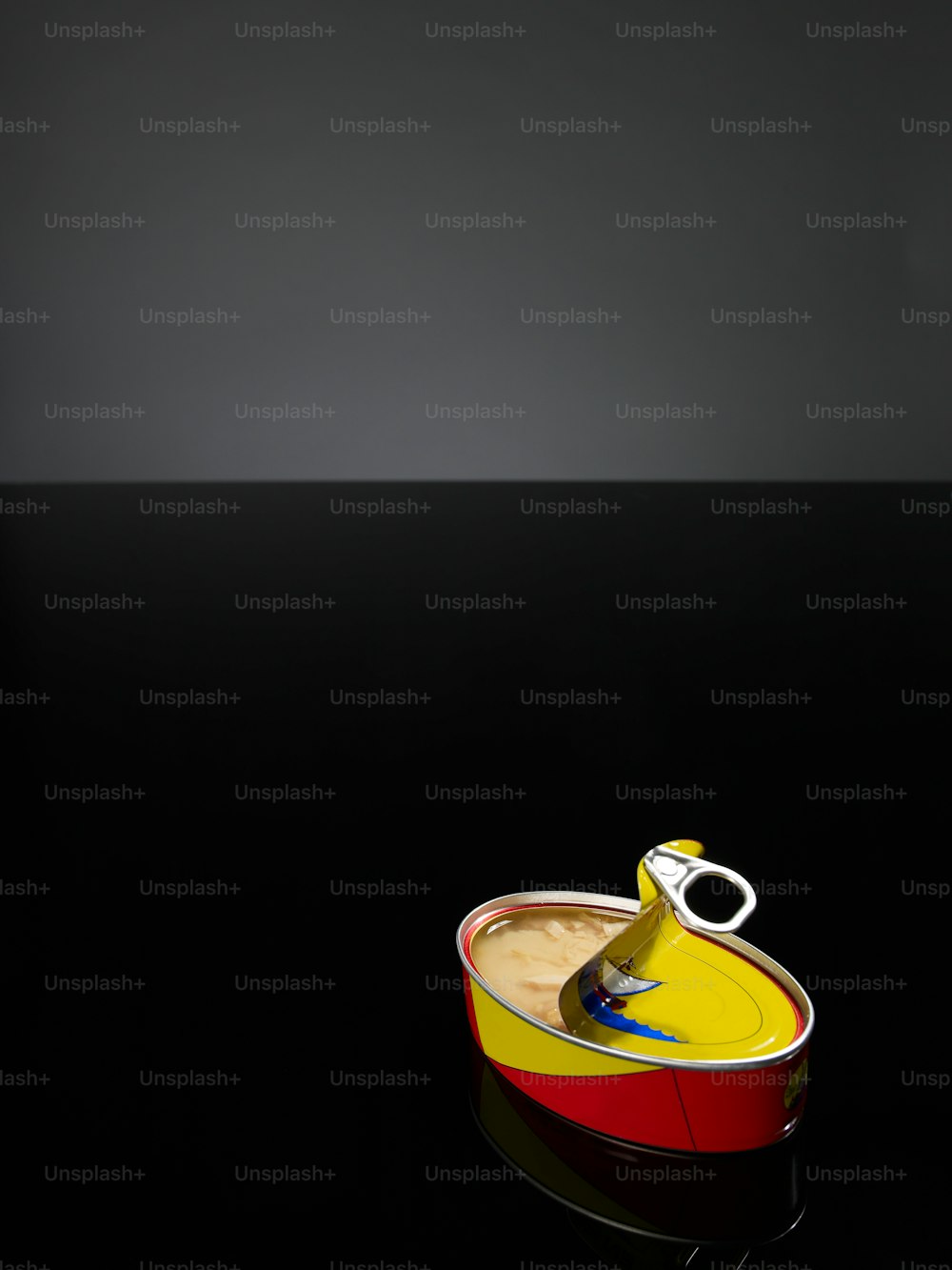 uma lata amarela e vermelha com uma tesoura