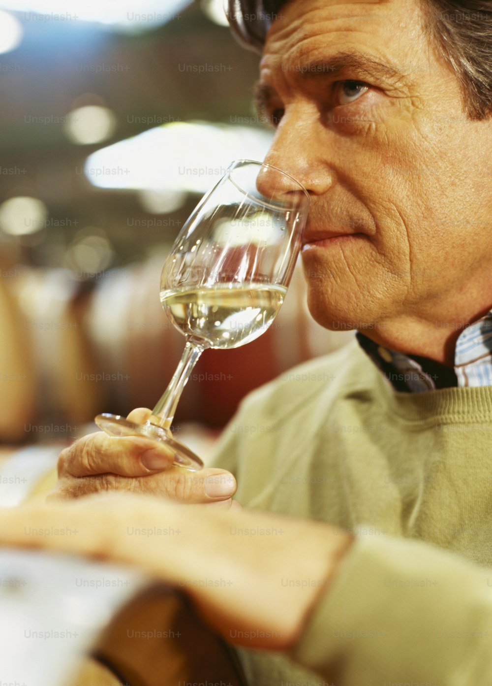 um homem bebendo uma taça de vinho branco