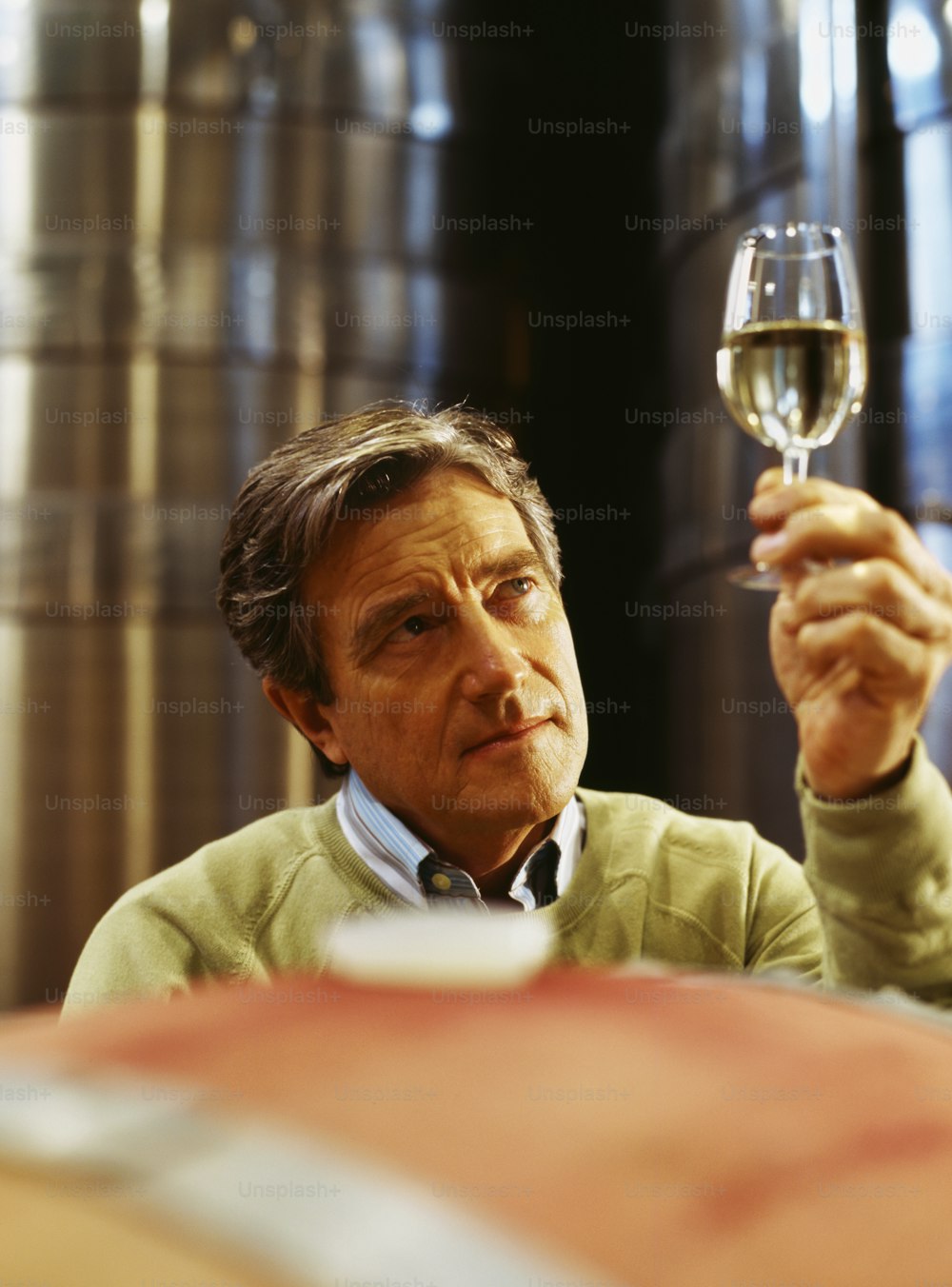 Un hombre sosteniendo una copa de vino en la mano