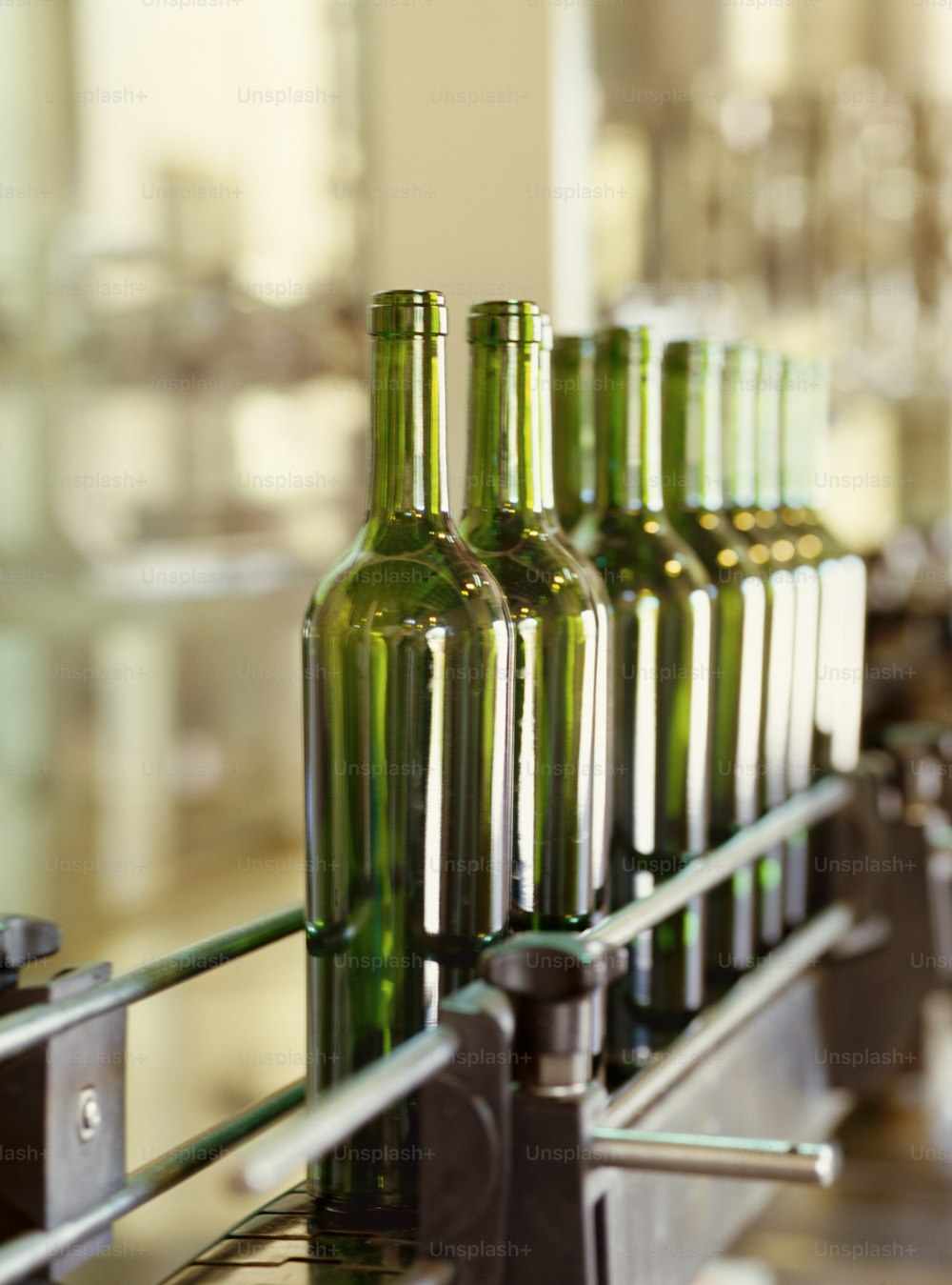 a row of green bottles sitting on top of a conveyor belt