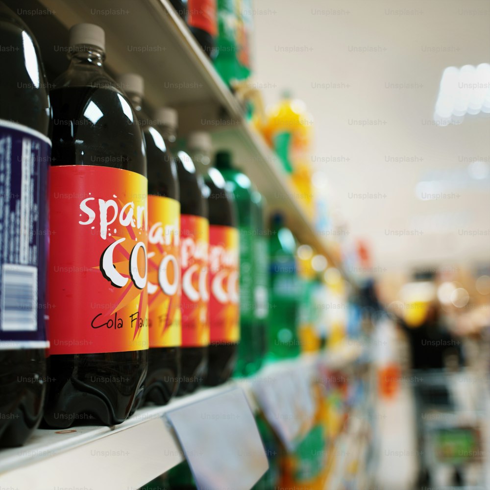 bottles of soda sit on a shelf in a store