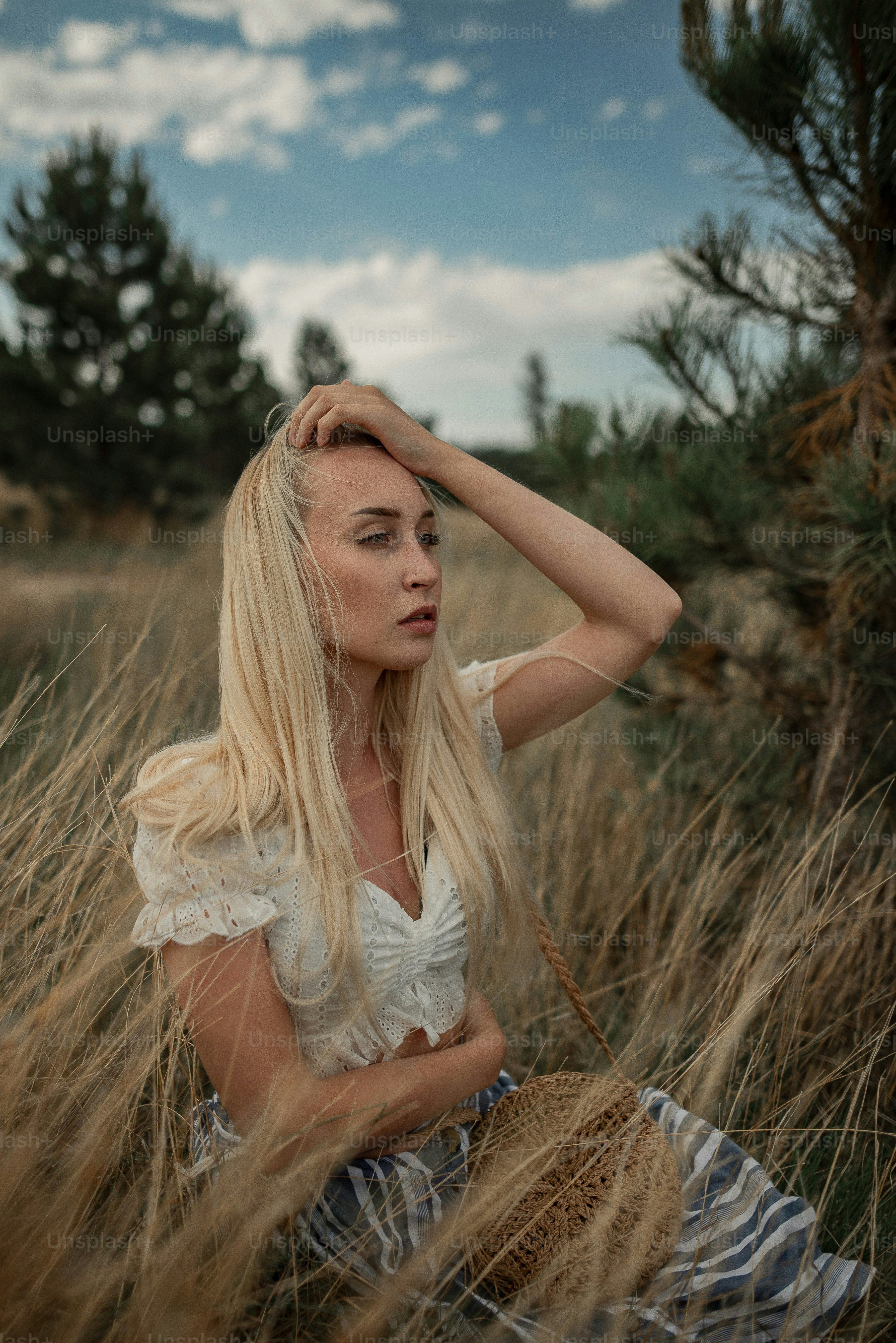 a woman sitting in a field of tall grass