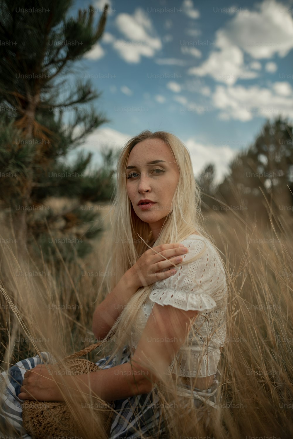 a woman sitting in a field of tall grass