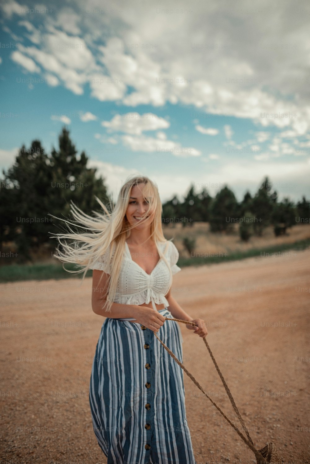 uma mulher com longos cabelos loiros segurando um pau