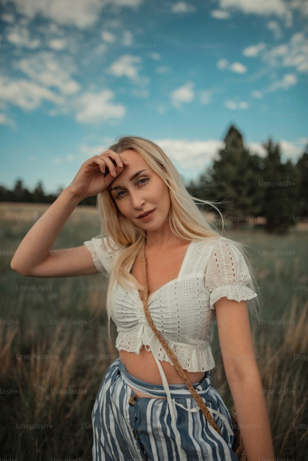 Eine schöne blonde Frau, die auf einem Feld steht