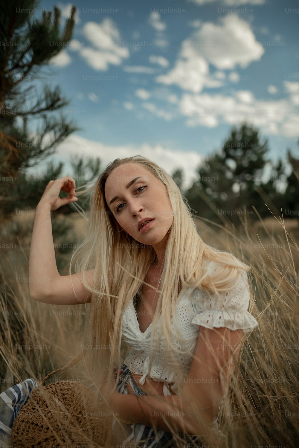 a woman sitting in a field of tall grass