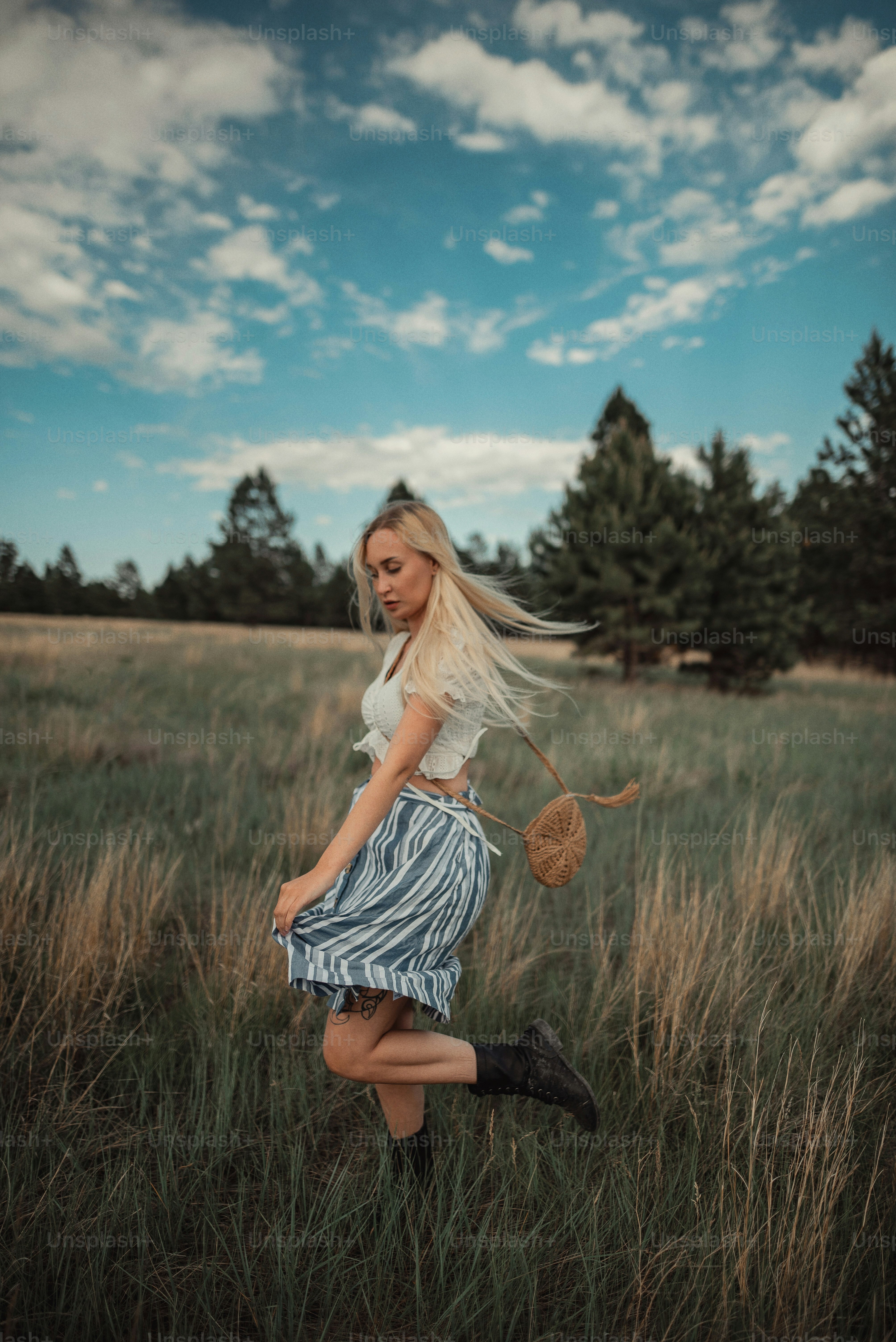 a woman standing in a field with a hat