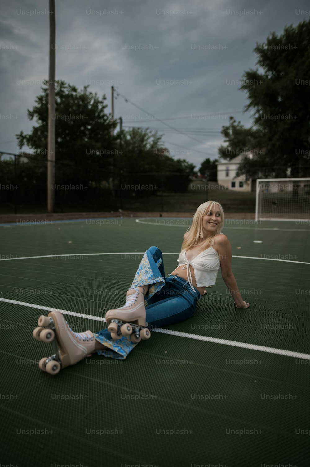 a woman sitting on the ground with a skateboard