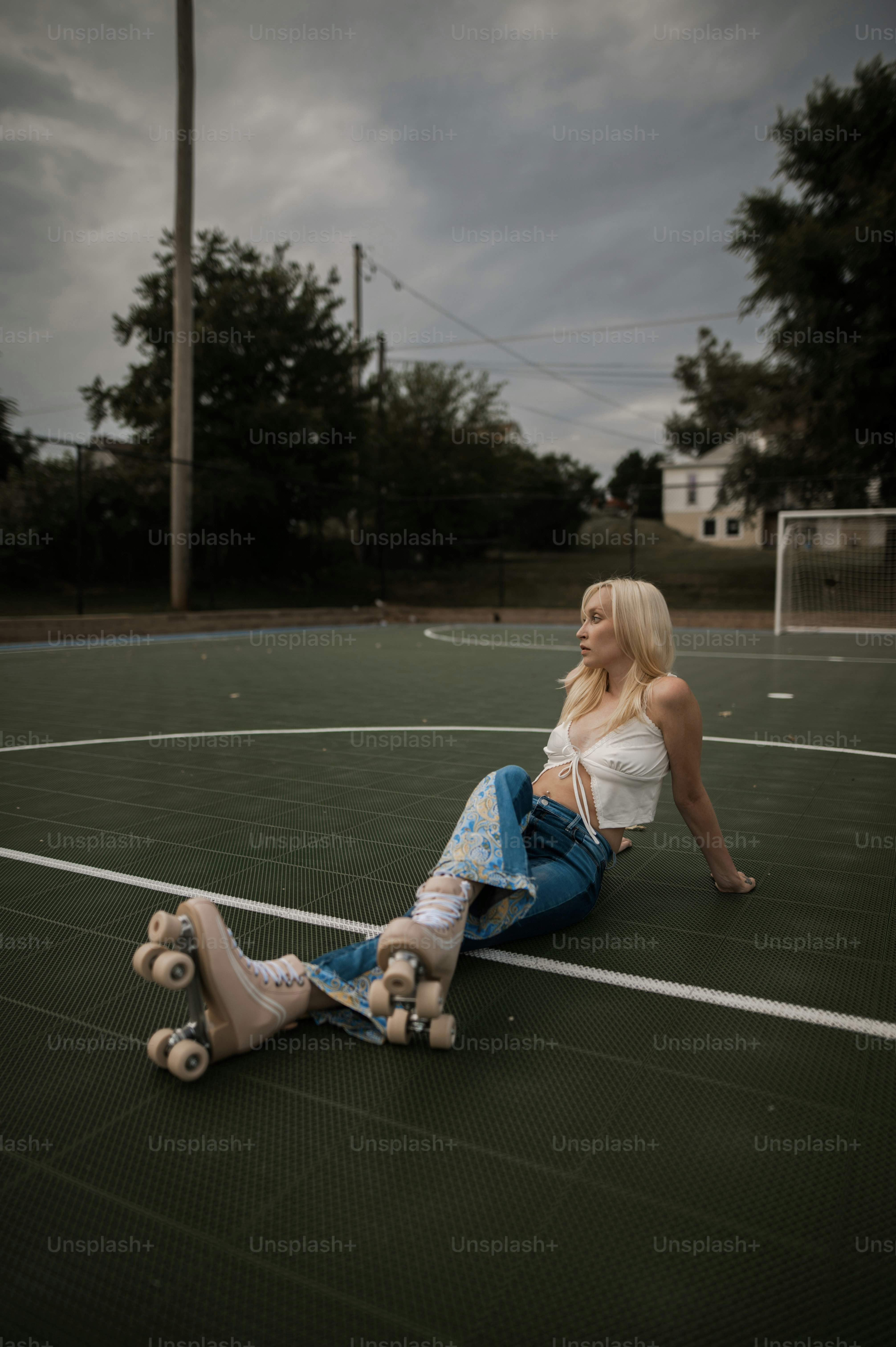 a woman sitting on the ground with a skateboard