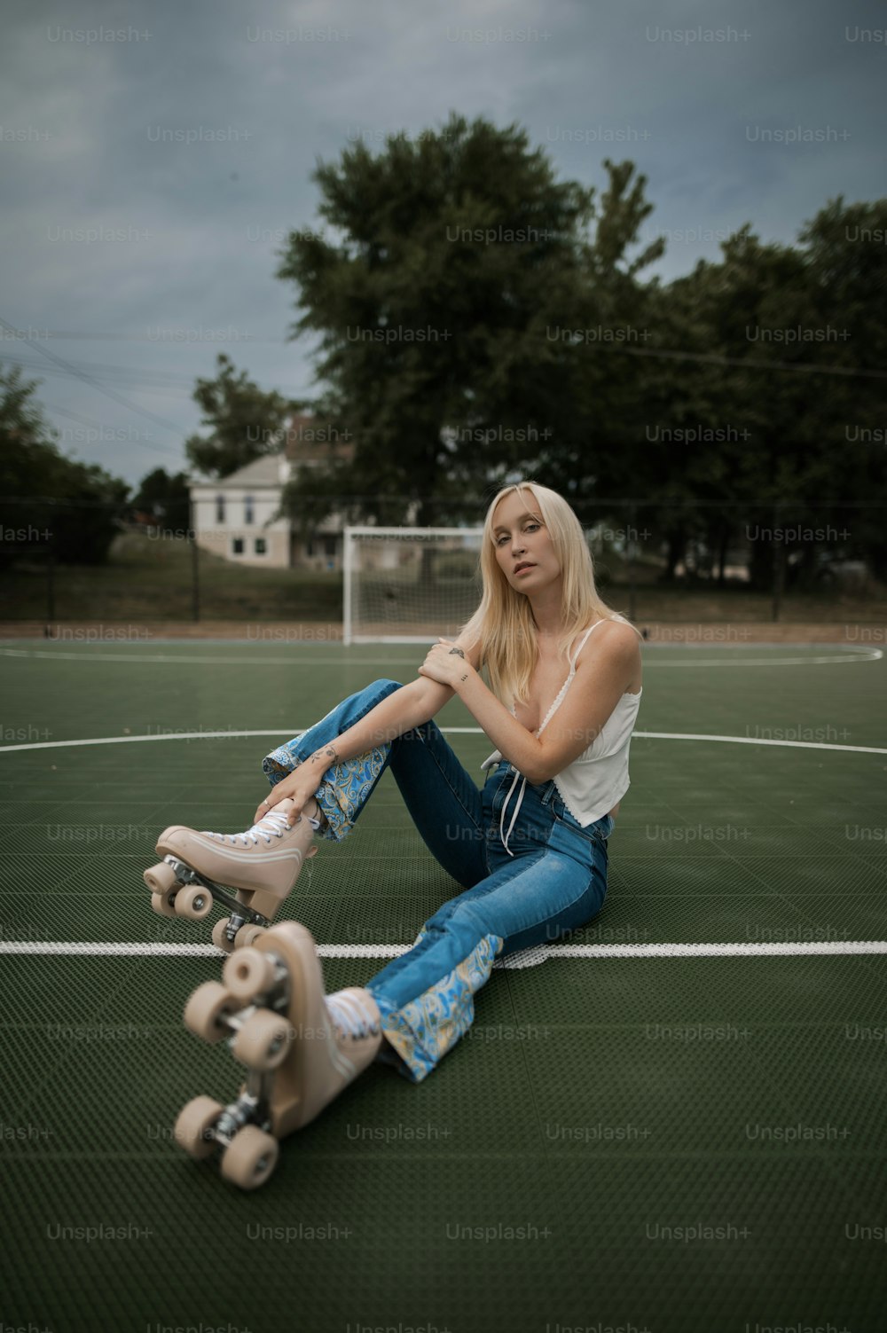 a woman sitting on the ground with her skateboard