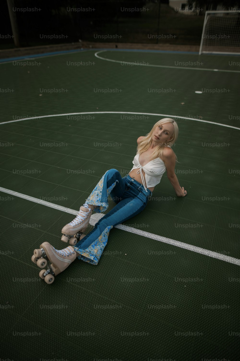 a woman laying on a basketball court with her feet on the ground