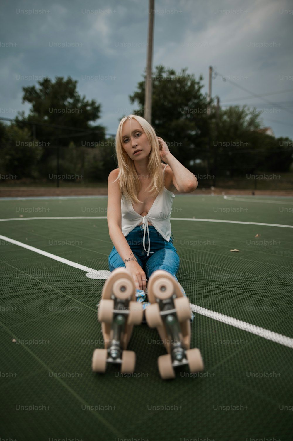 uma mulher sentada em cima de um skate em uma quadra