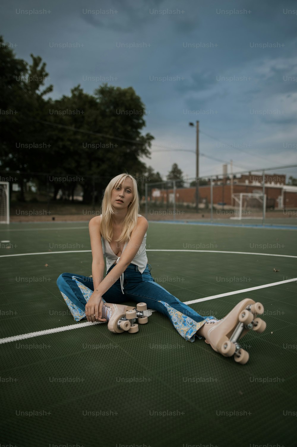 uma mulher sentada no chão com seu skate