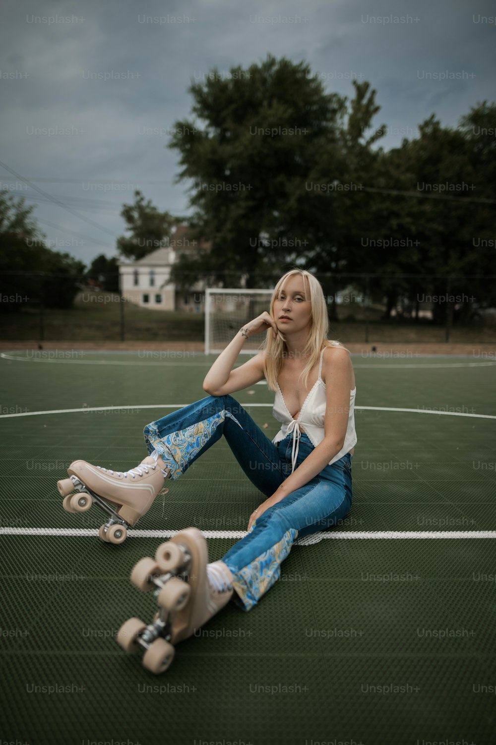 uma mulher sentada no chão com um skate