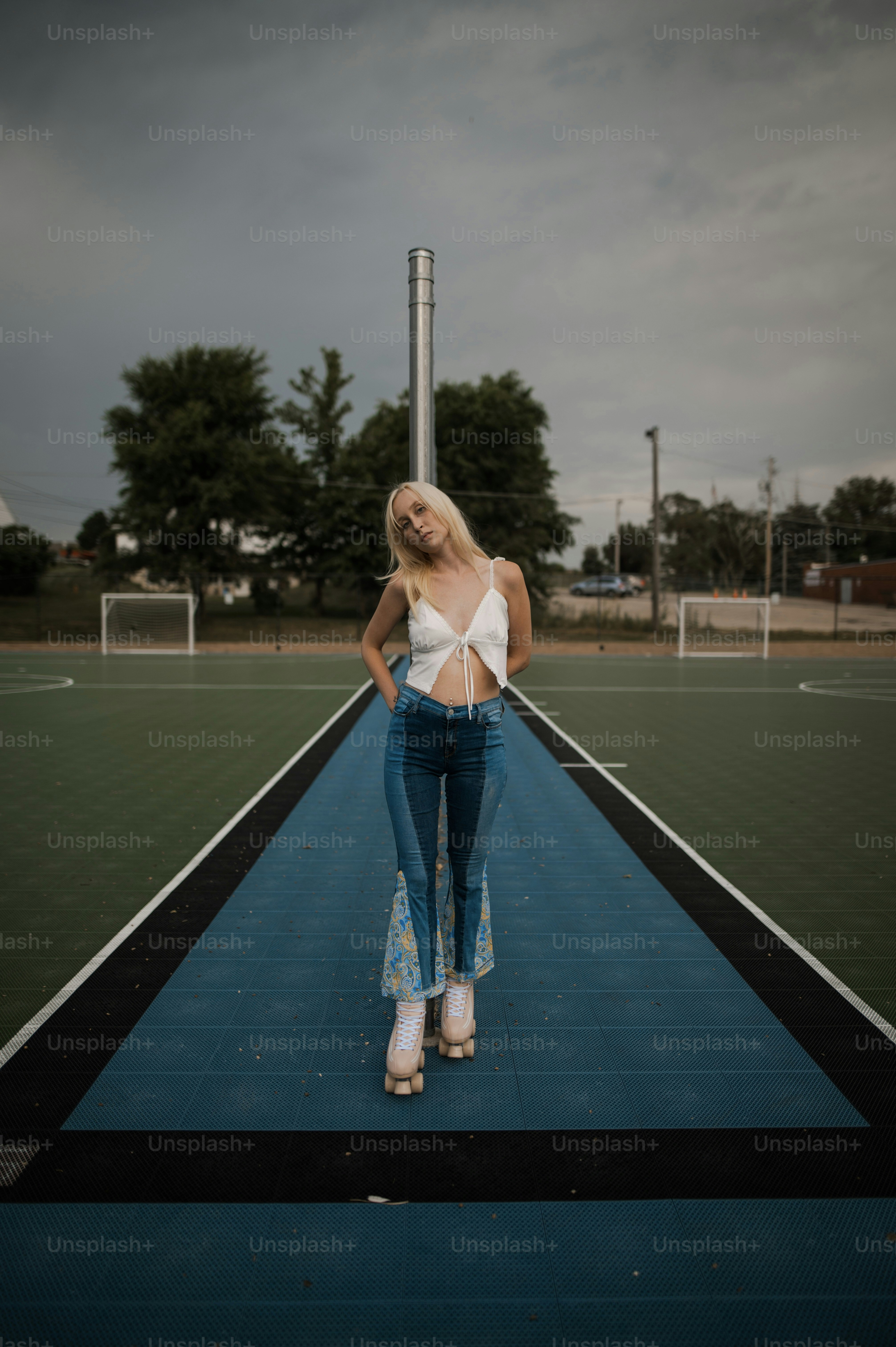 Una mujer parada en una cancha de tenis con las manos en las caderas