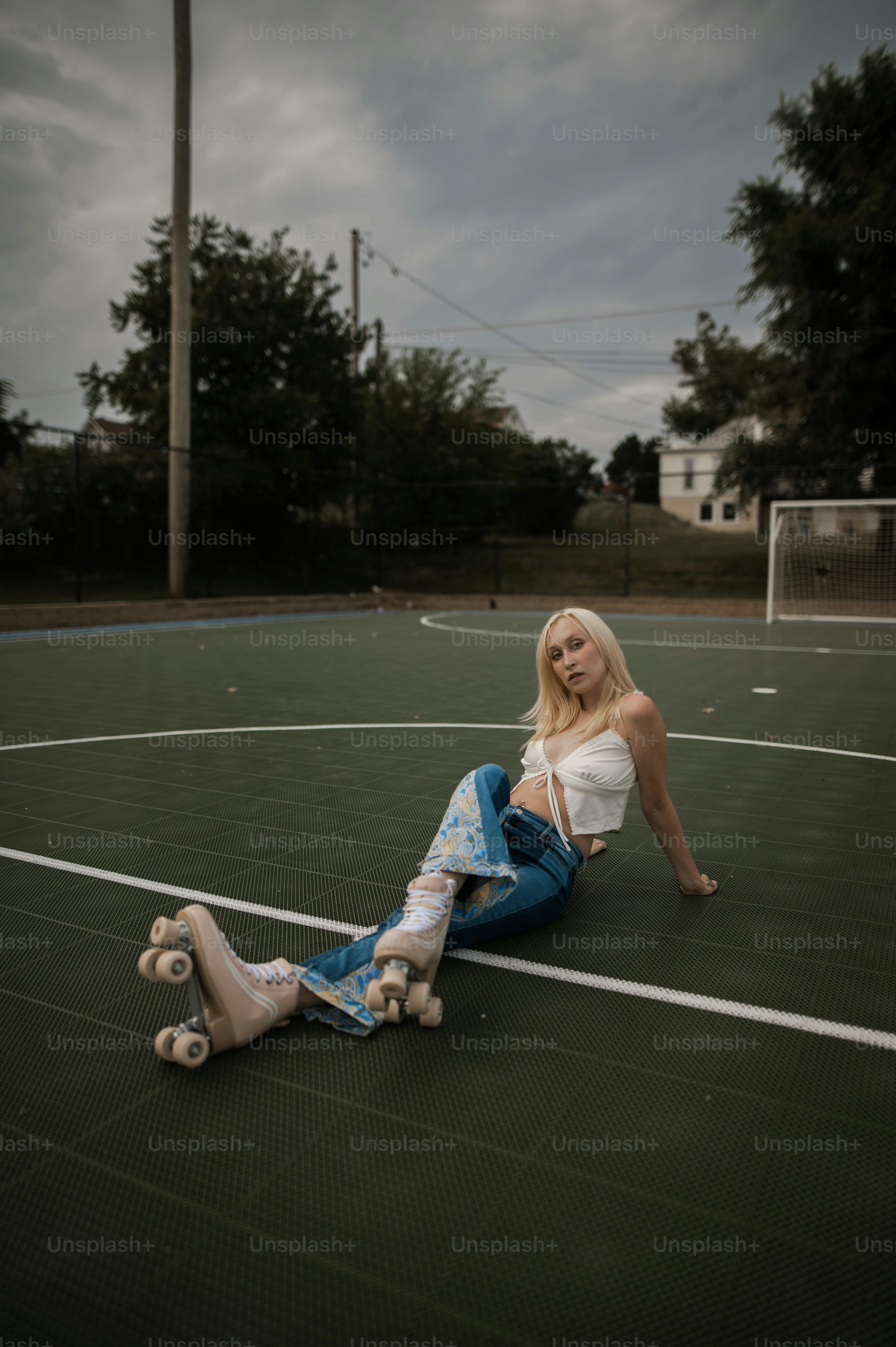 a woman sitting on the ground with a skateboard