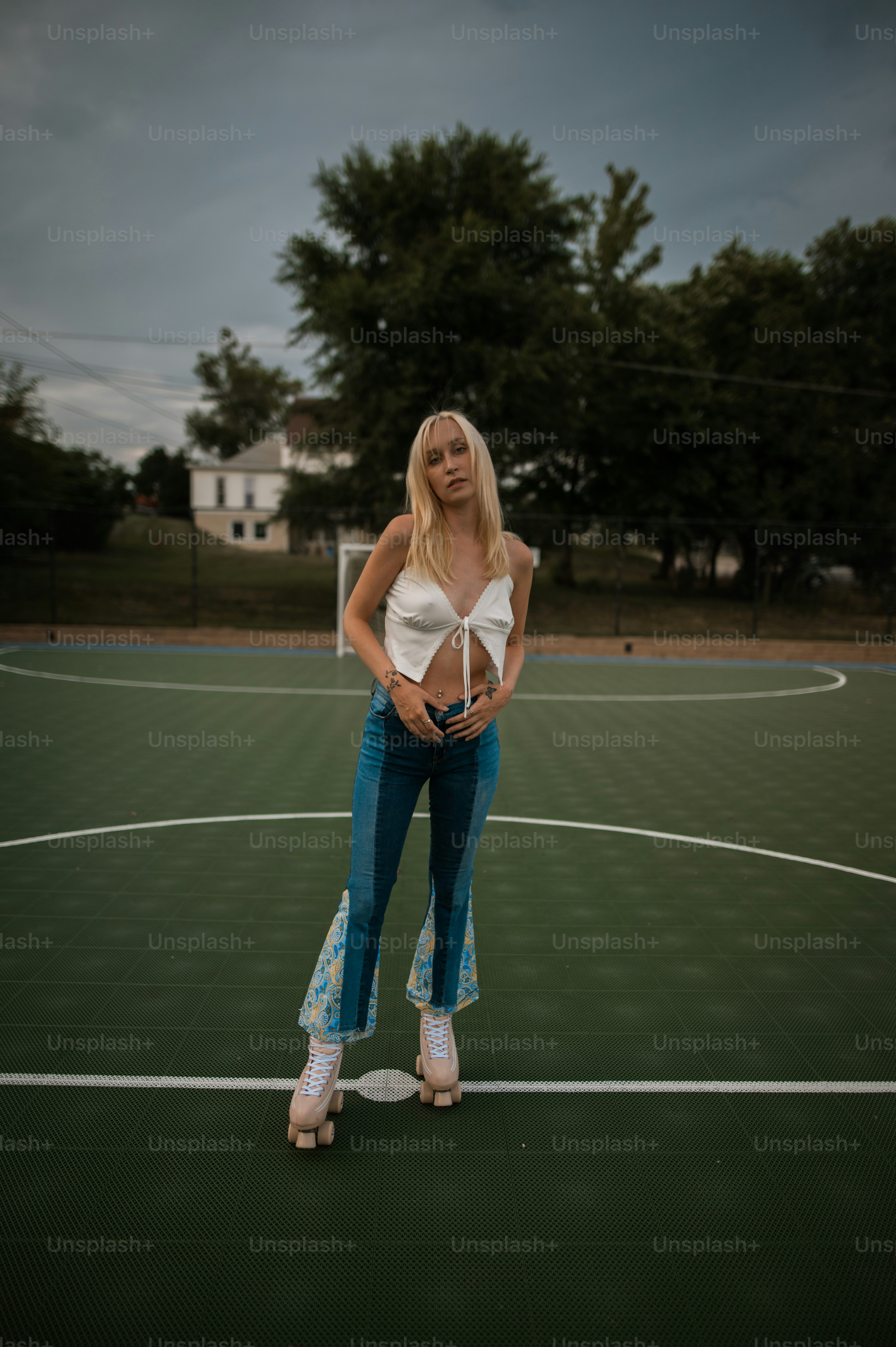 a woman standing on a basketball court with her hands in her pockets