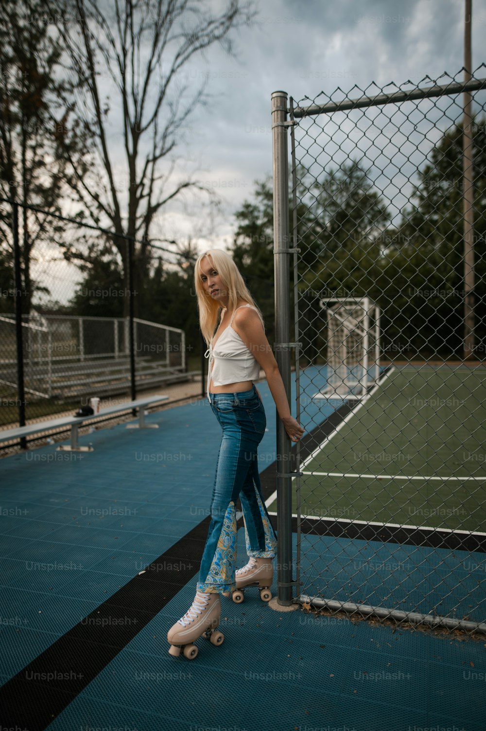 a woman standing on a skateboard on a tennis court