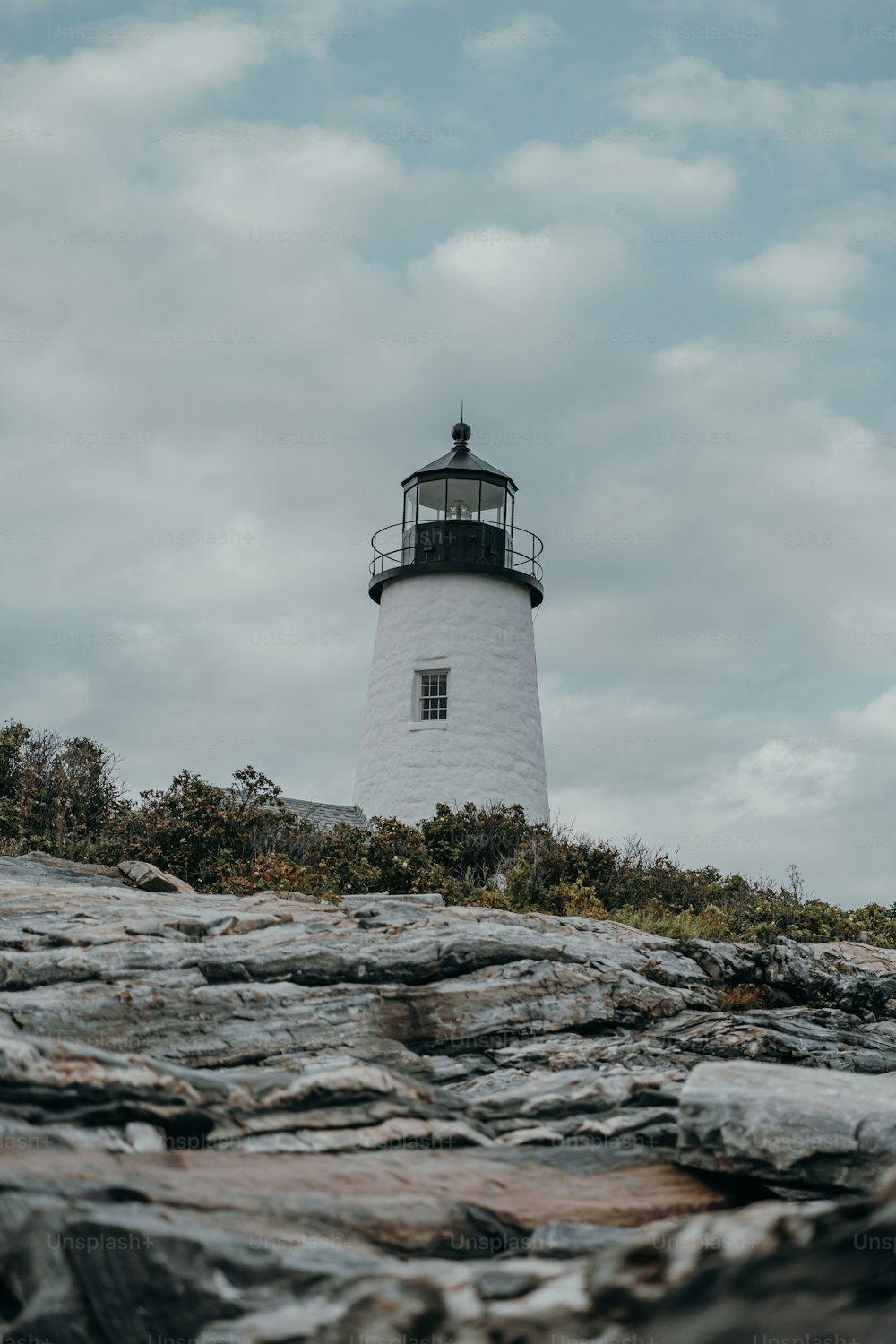 a lighthouse on top of a rocky hill