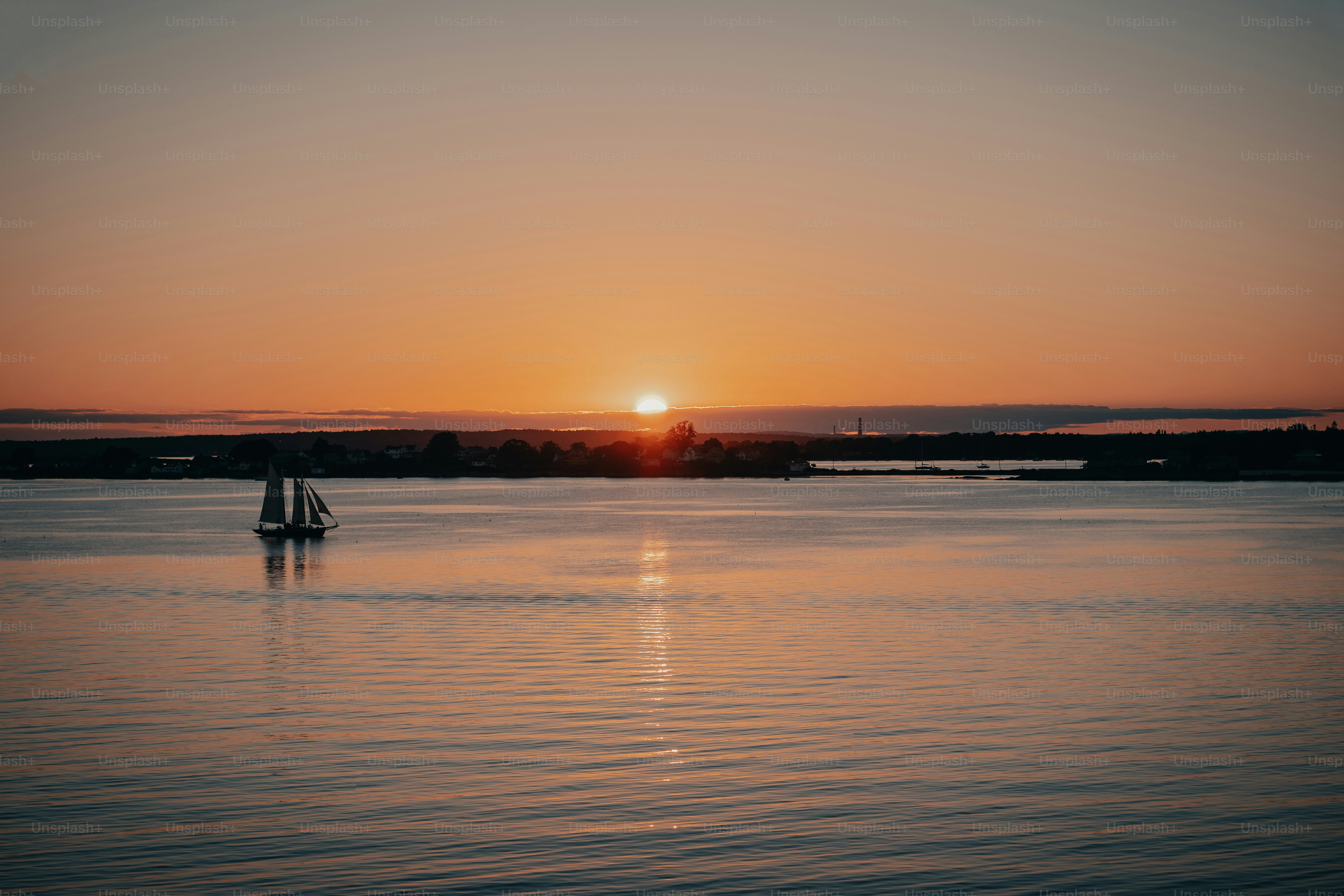 a sailboat in a body of water at sunset