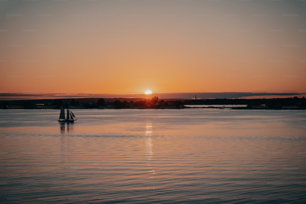 una barca a vela in uno specchio d'acqua al tramonto