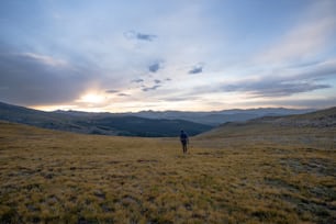 a man standing on top of a grass covered field