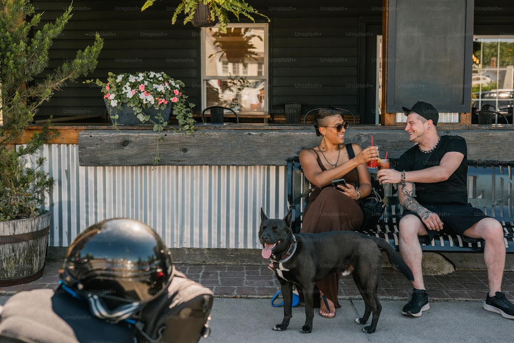 um homem e uma mulher sentados em um banco com um cachorro