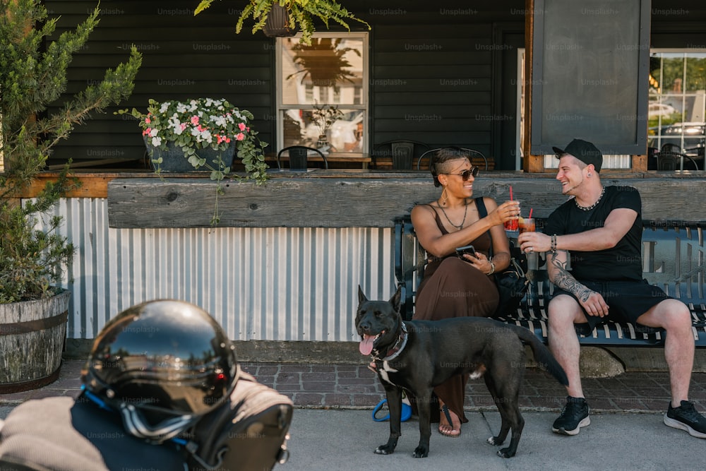 a man and woman sitting on a bench with a dog